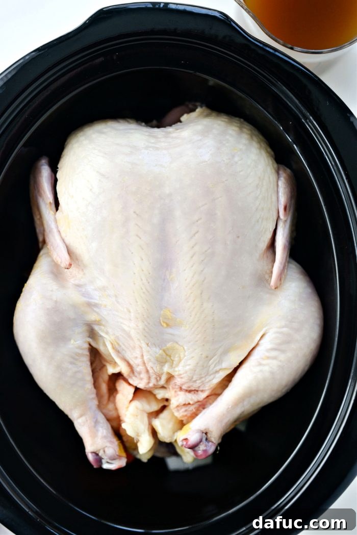 Fall-Off-The-Bone Slow Cooker Chicken 6 Whole chicken placed on top of chopped vegetables in slow cooker