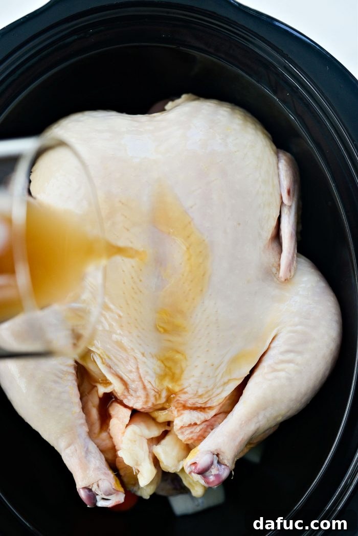 Fall-Off-The-Bone Slow Cooker Chicken 7 Chicken bone broth being poured over the whole chicken