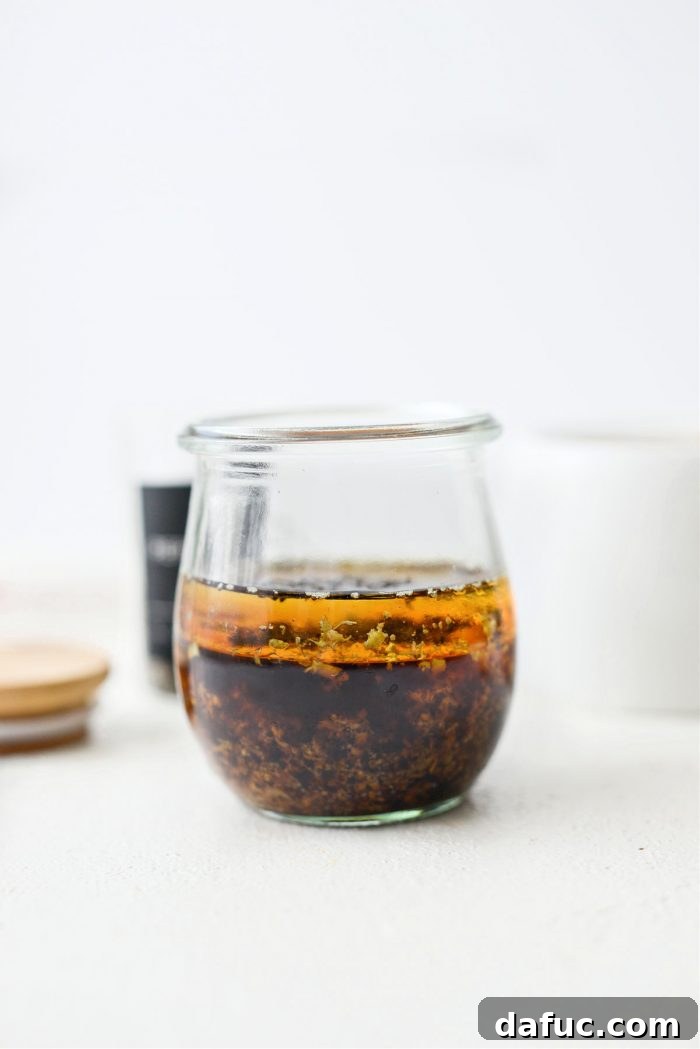 Crunchy Asian Chicken Salad 6 Dressing ingredients being measured and added into a glass jar