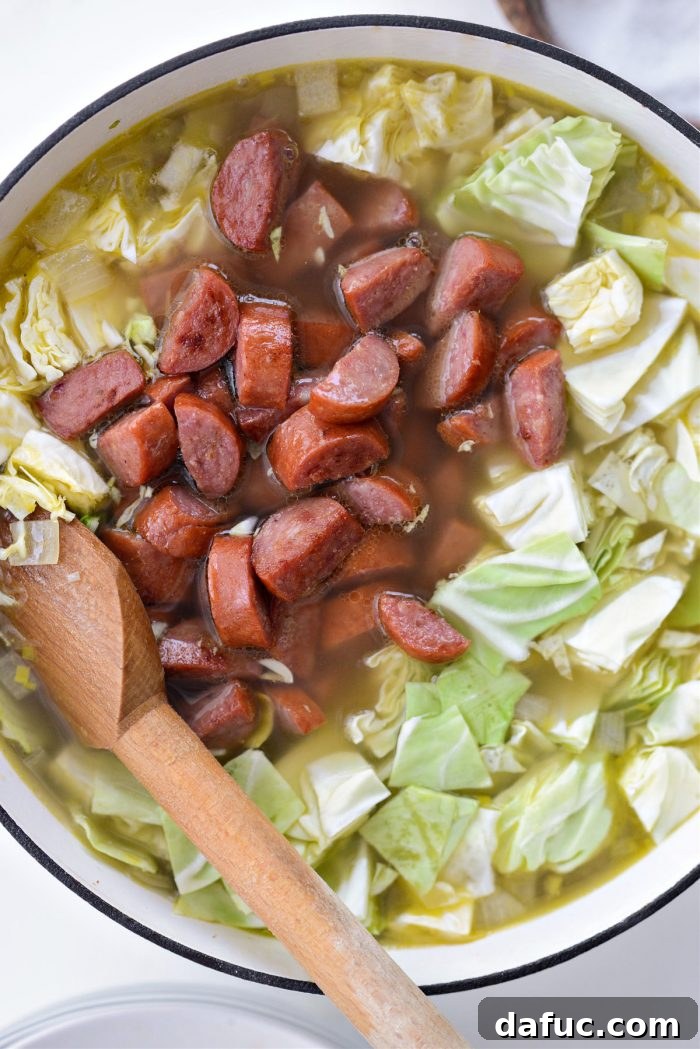 Add cabbage and browned kielbasa to the soup