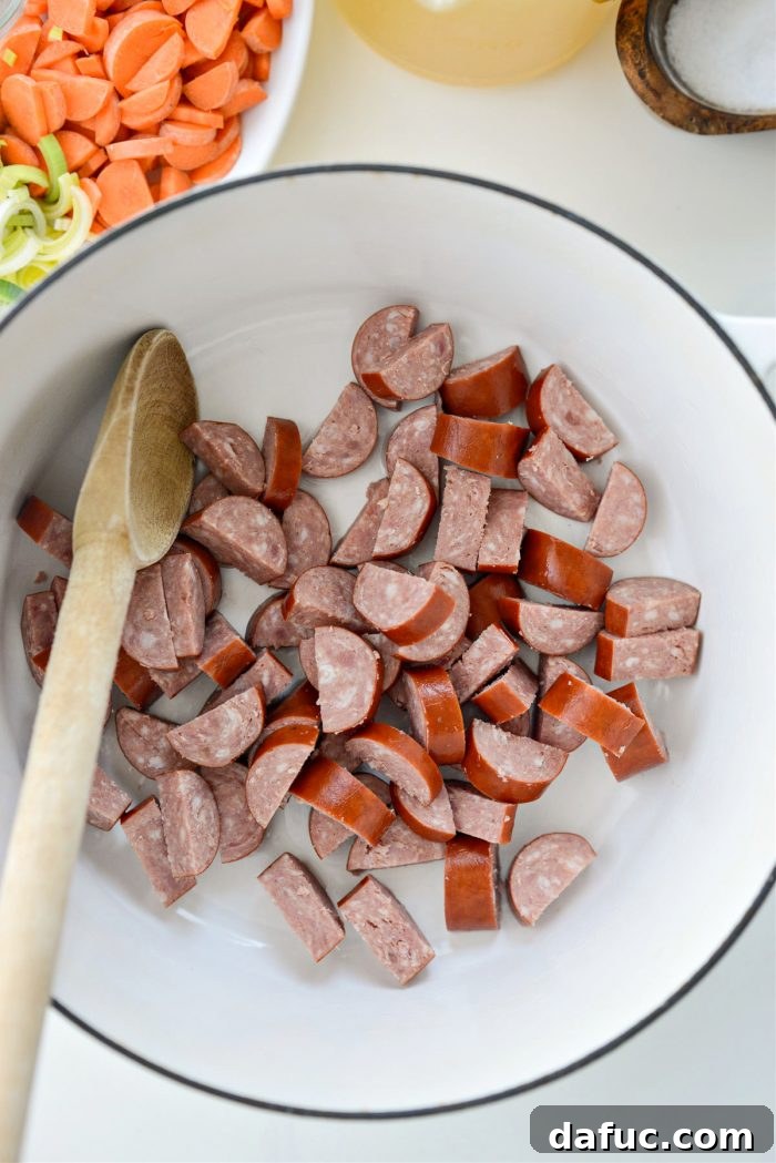 Add olive oil and sliced kielbasa to a Dutch oven