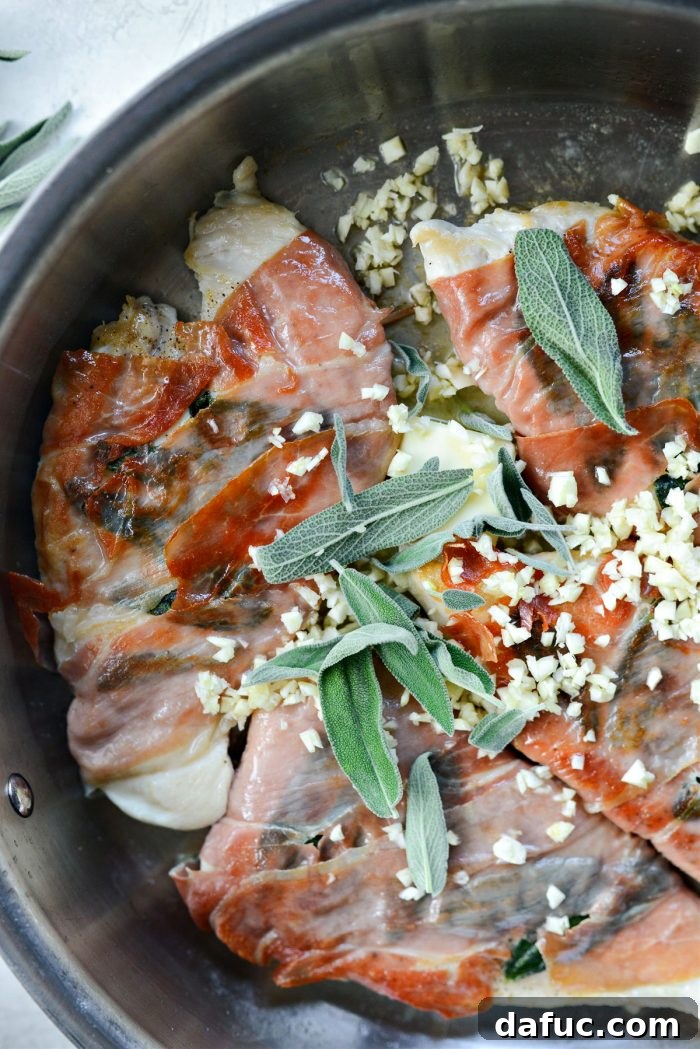 Flipping chicken and adding butter, garlic, and sage leaves to the pan