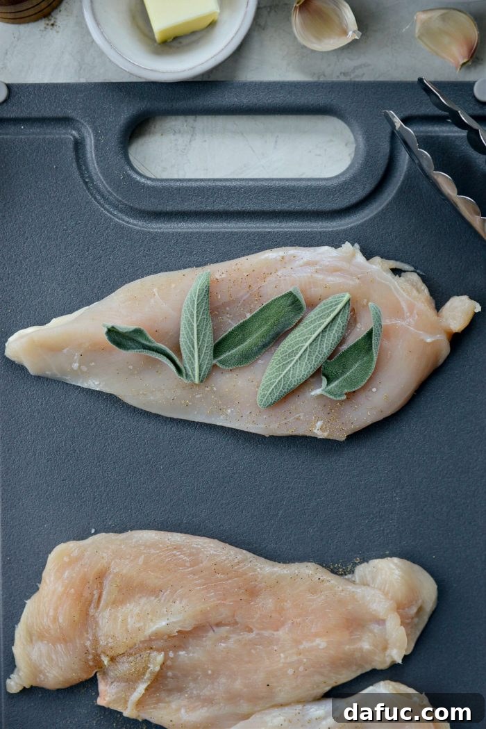 Placing fresh sage leaves on chicken breasts