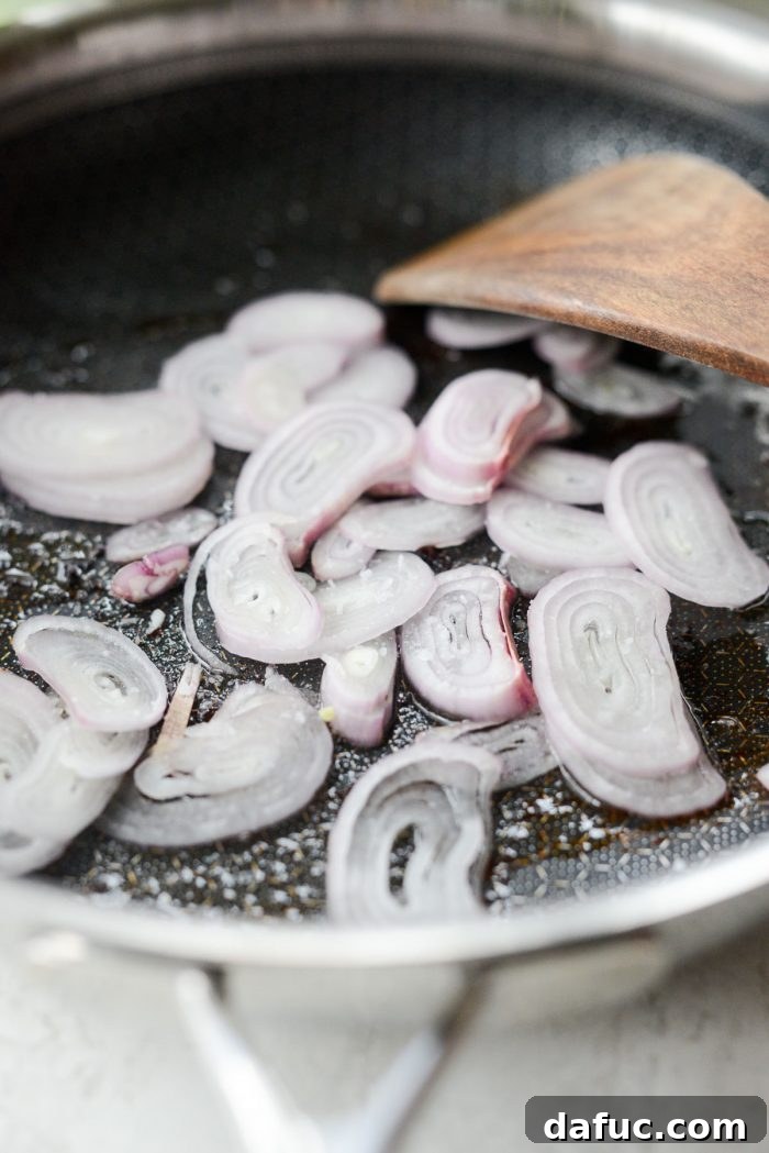 Shallots frying in bacon grease in a skillet