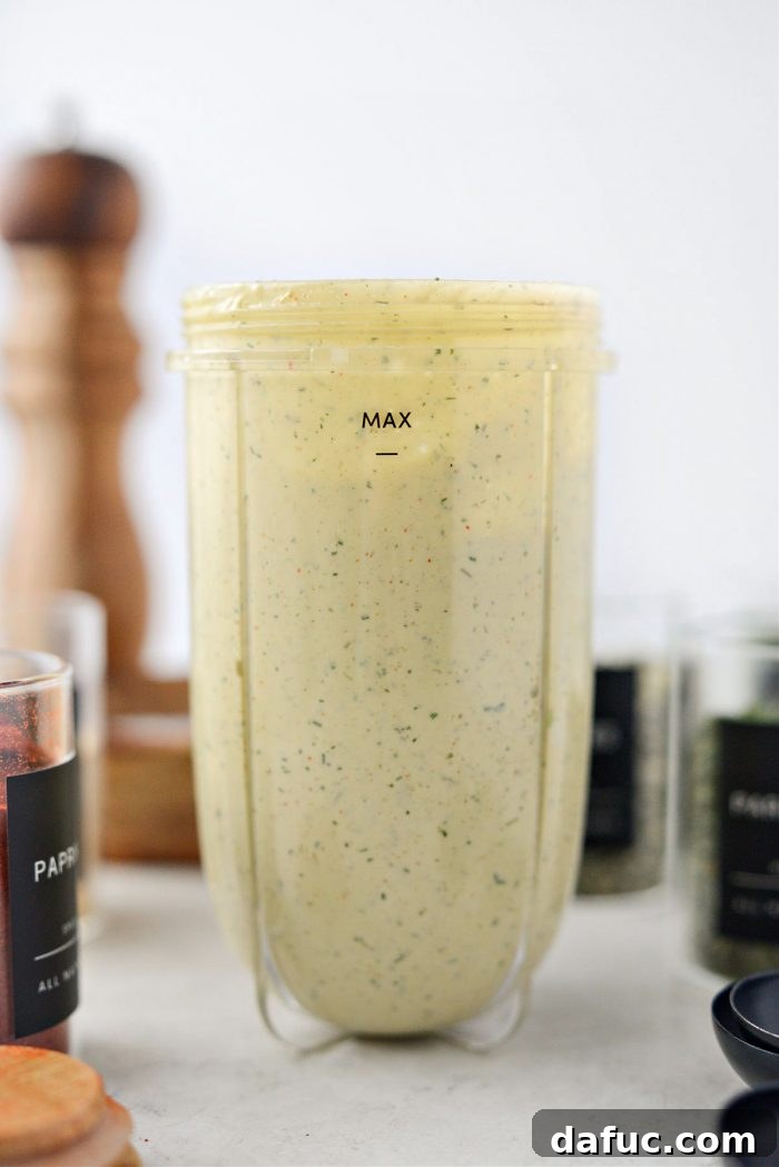 Adding spices and water to the blender for avocado ranch