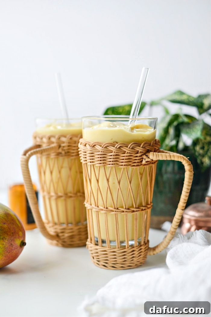 Liquid Sunshine Mango 12 A close-up of the Golden Hour Mango Smoothie in a glass, with a straw, inviting a sip.
