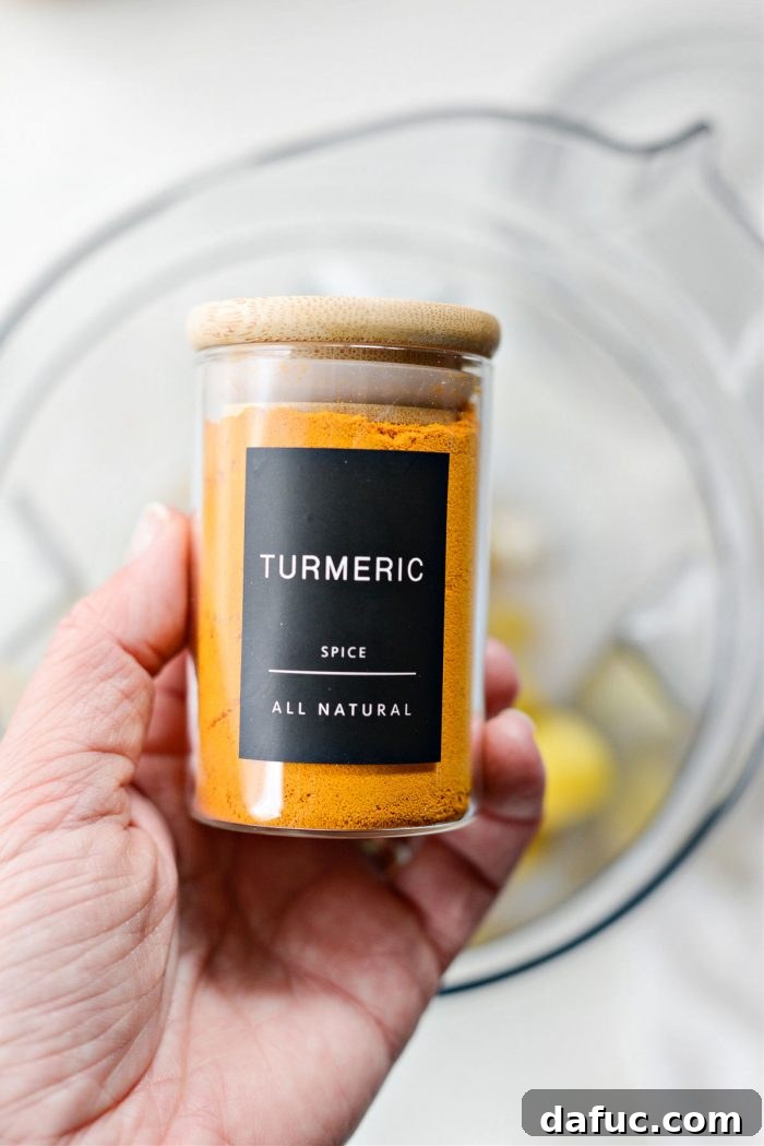 Liquid Sunshine Mango 5 A small glass jar of ground turmeric powder, highlighting a key ingredient.