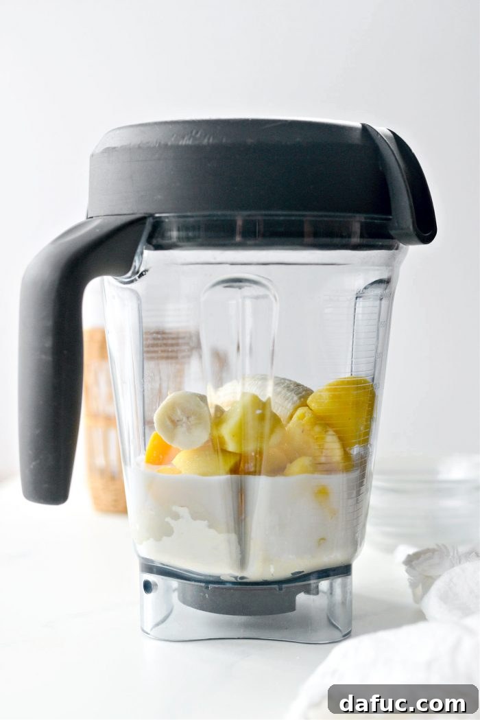 Liquid Sunshine Mango 9 A blender with its lid securely placed, ready for blending.