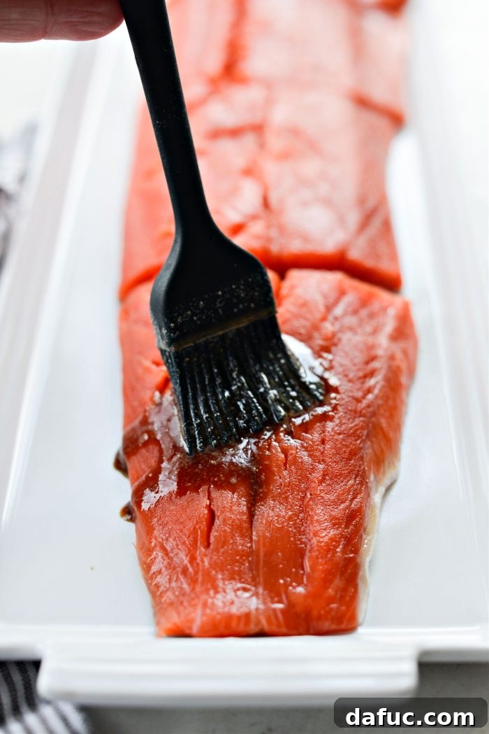 Salmon fillets being brushed with the sriracha marinade
