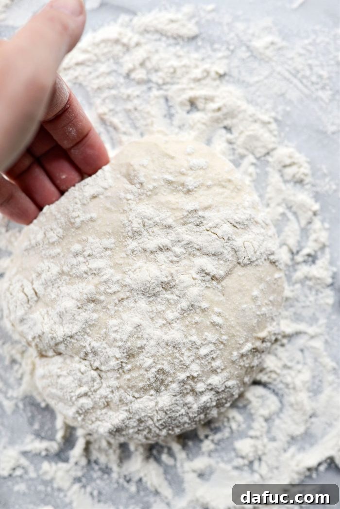 Gently shaping pizza dough into a ball with fingertips