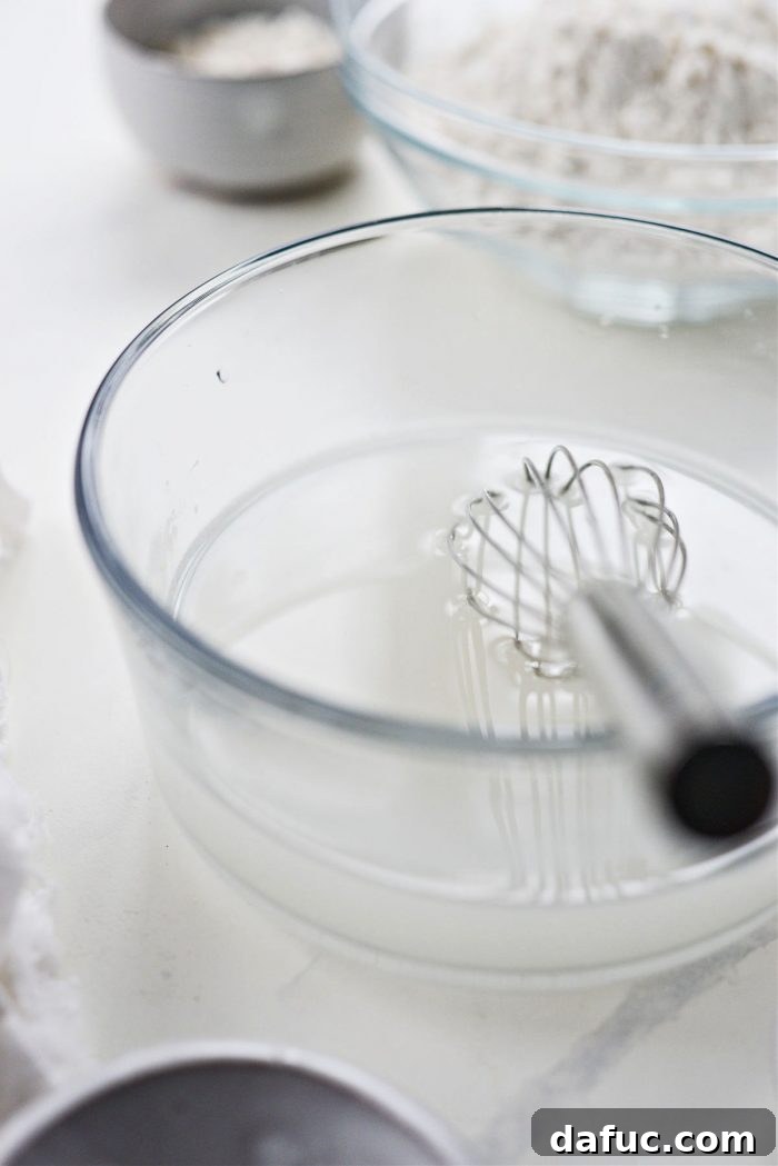 Whisking lukewarm water with yeast and sugar to activate