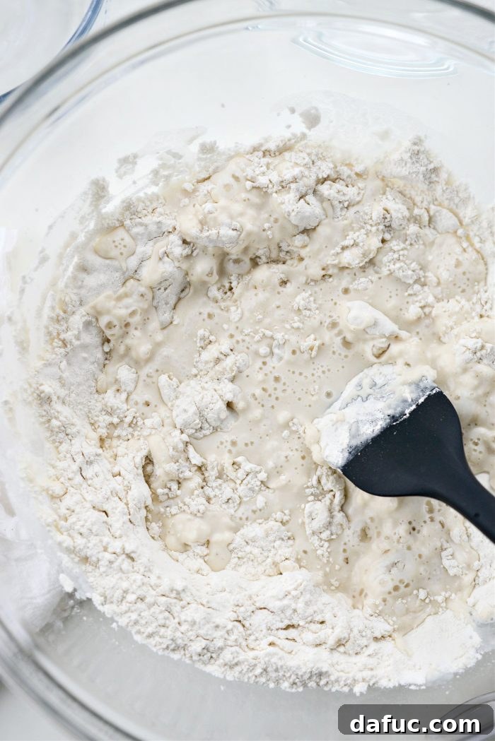 Stirring pizza dough with a rubber spatula until combined