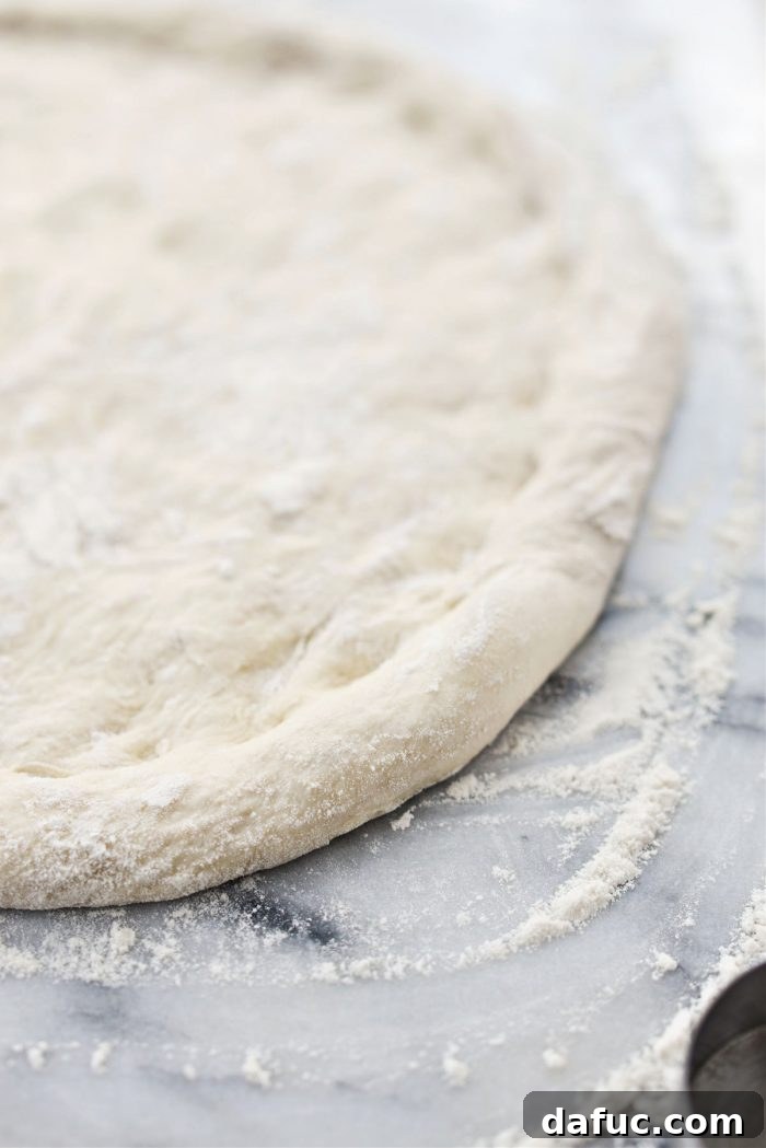 Close-up of pizza dough with a defined crust edge