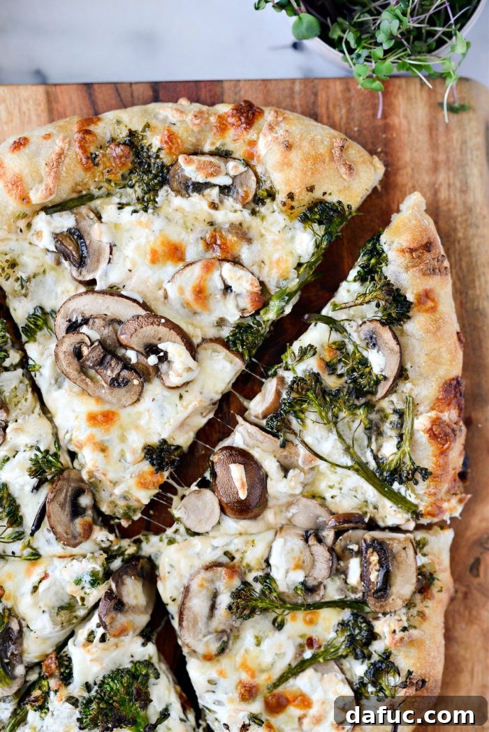 Freshly baked Green Forest Pizza being sliced on a cutting board