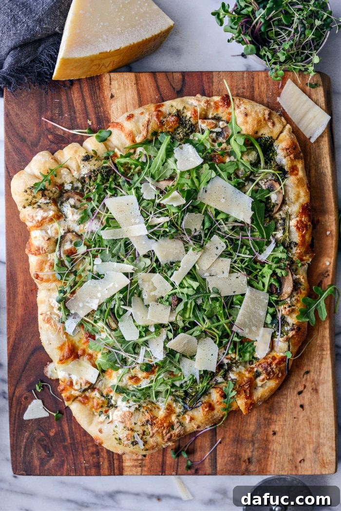 Green Forest Pizza topped with fresh arugula, microgreens, shaved Parmesan, and black pepper