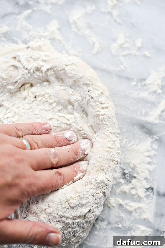 Hands gently stretching pizza dough into shape