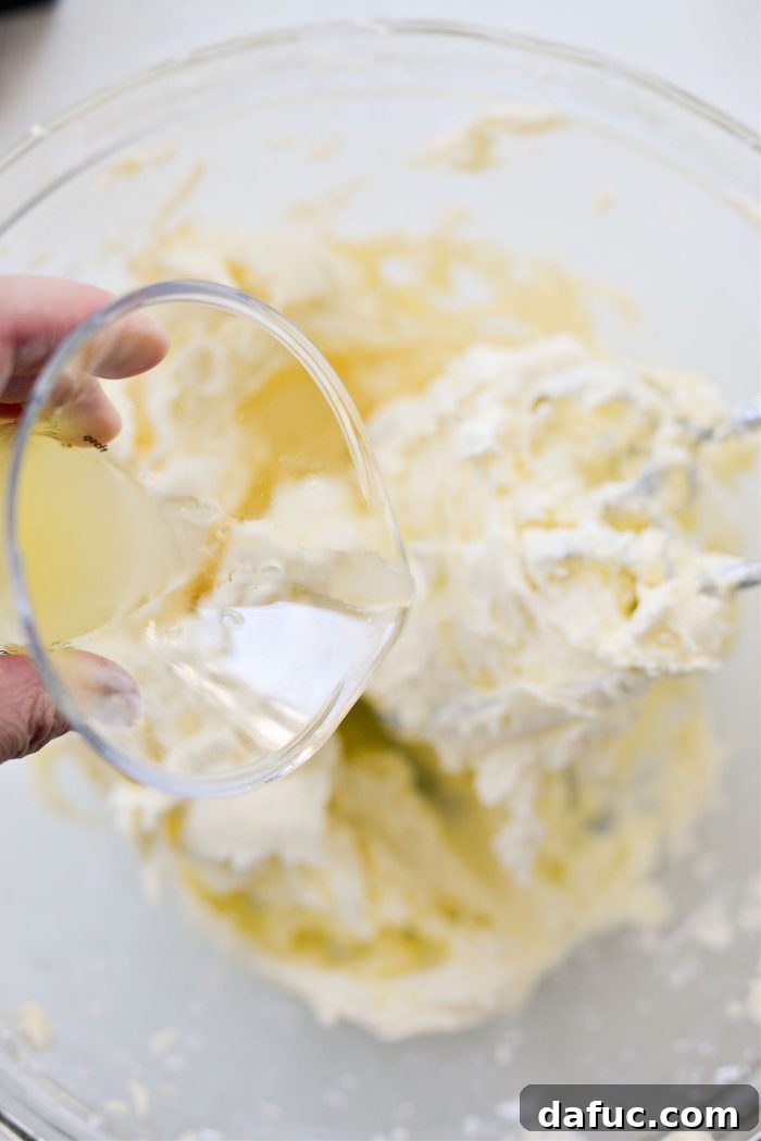Tangy Lemon Cupcakes with Velvety Frosting 15 Freshly squeezed lemon juice being added to the buttercream mixture
