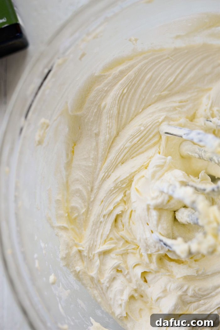 Tangy Lemon Cupcakes with Velvety Frosting 16 Buttercream being mixed after adding liquids and flavorings, showing a smooth, creamy texture