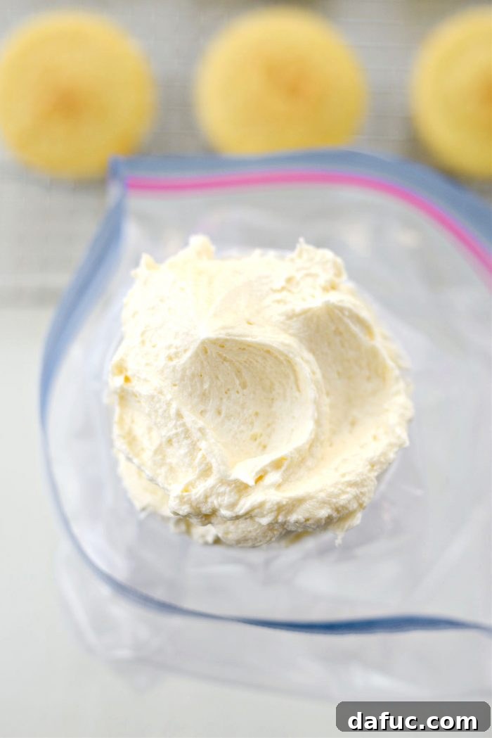 Tangy Lemon Cupcakes with Velvety Frosting 19 Lemon buttercream being transferred into a piping bag fitted with a decorative tip