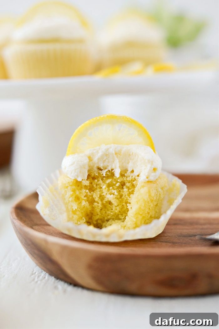 Tangy Lemon Cupcakes with Velvety Frosting 22 A single lemon cupcake with lemon buttercream frosting, held up close for a delicious presentation
