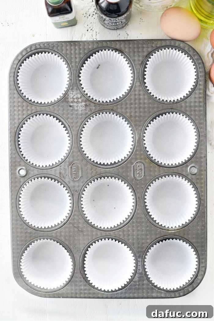 Tangy Lemon Cupcakes with Velvety Frosting 5 A standard muffin pan lined with white paper cupcake liners, ready for batter