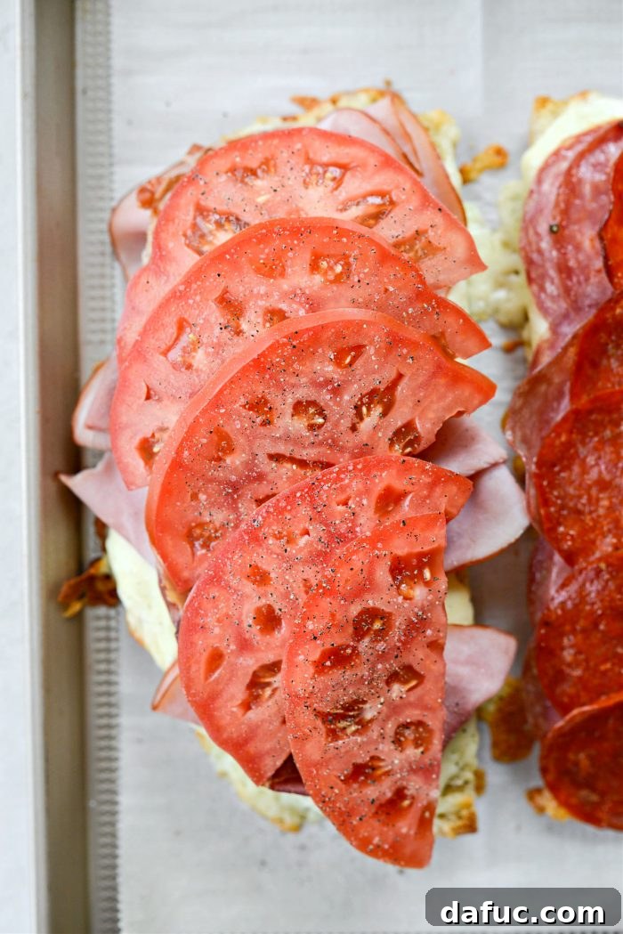 Old World Italian Sub 15 Bottom half of the sandwich topped with fresh tomato slices, seasoned with salt and pepper.