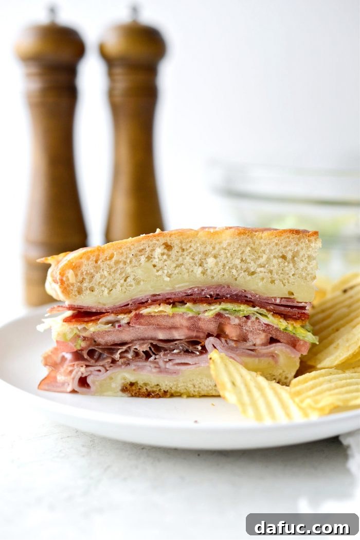 Old World Italian Sub 21 Italian Grinder sandwich on a cutting board with a knife, ready to be enjoyed.