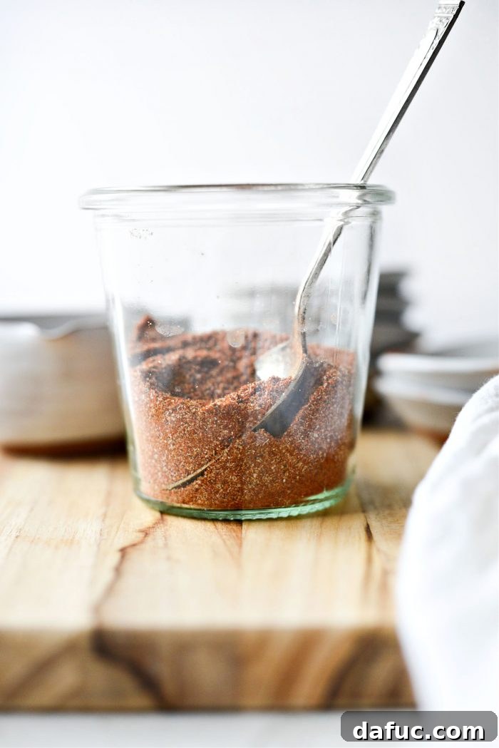 A small glass jar filled with vibrant homemade Street Taco Seasoning, ready for use.