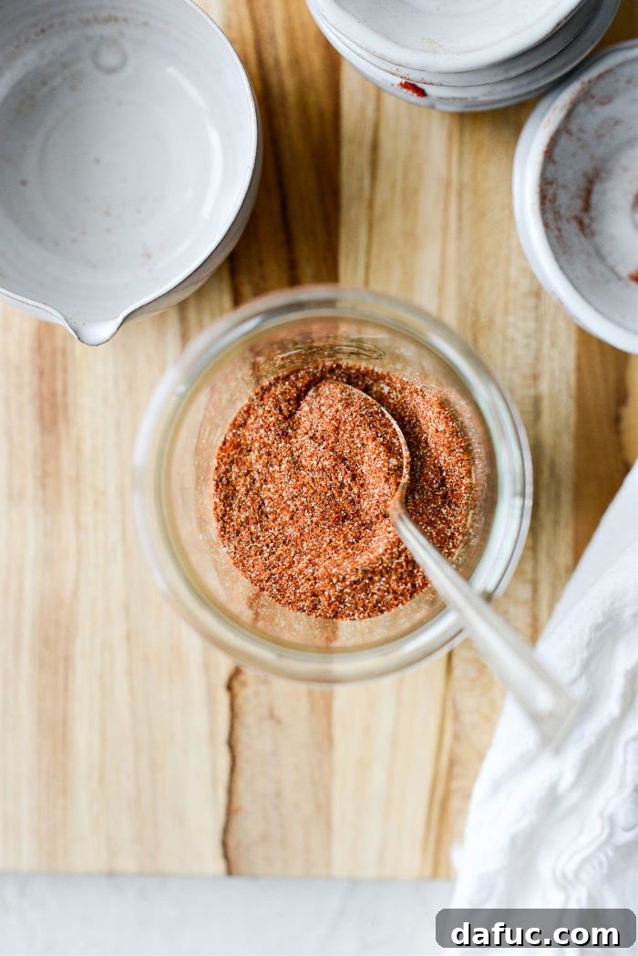 A clear glass jar proudly displaying the freshly mixed, reddish-brown homemade Street Taco Seasoning.