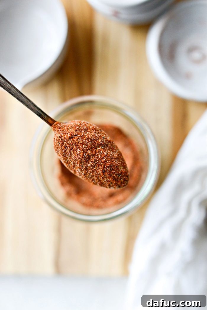 A spoon overflowing with rich, red Street Taco Seasoning, highlighting its texture and color.