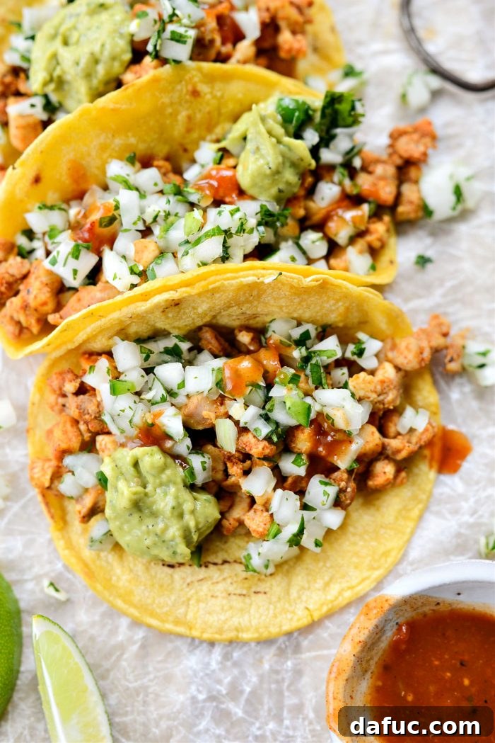 A top-down view of multiple Chicken Street Tacos, garnished and ready to be served
