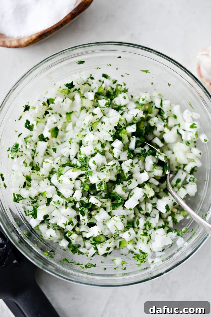 Stirring the onion salsa ingredients in a bowl to combine them thoroughly