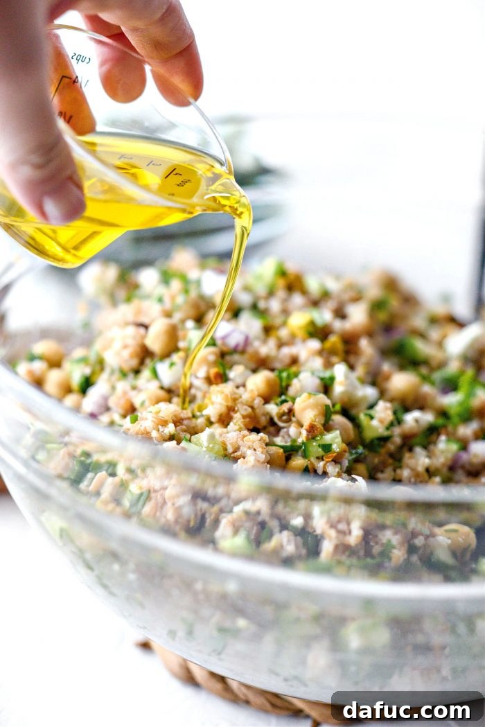 Pouring olive oil into the Jennifer Aniston Salad