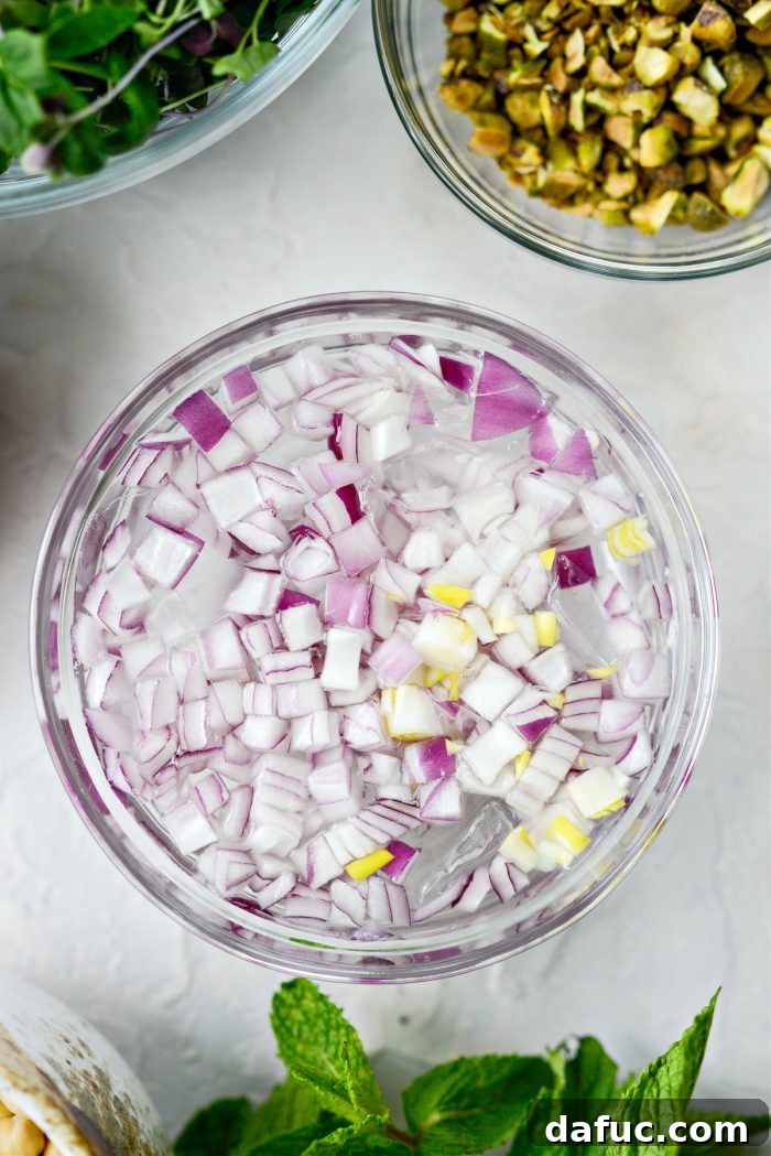 Diced red onions soaking in a bowl of ice water