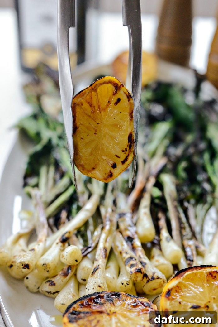 Charred Ramps Perfection 24 Squeezing juice from a grilled lemon half over ramps