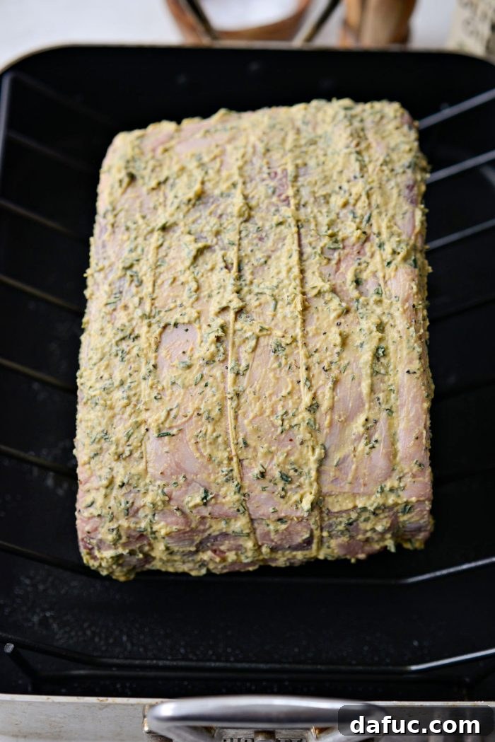 Rosemary Dijon Crusted Prime Rib with Pinot Noir Au Jus 17 Dijon rosemary rib roast on rack in roasting pan.