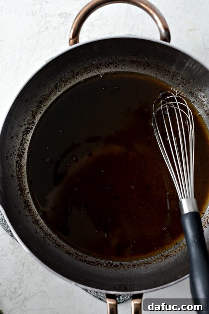 Rosemary Dijon Crusted Prime Rib with Pinot Noir Au Jus 23 Reduced Pinot Noir au jus in a saucepan.