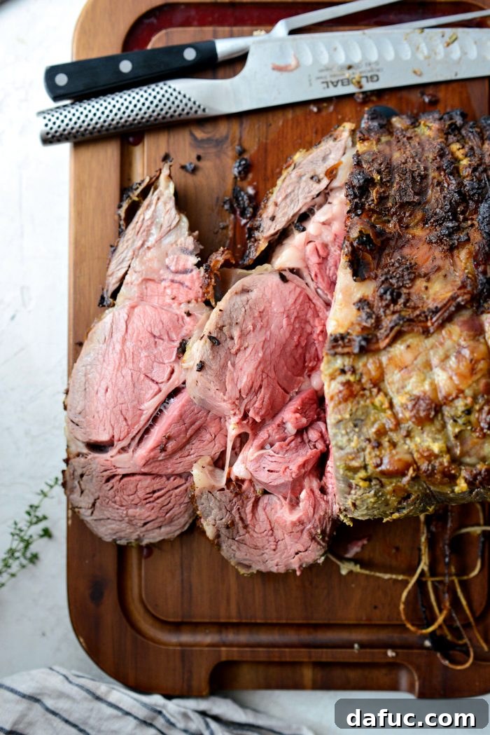 Rosemary Dijon Crusted Prime Rib with Pinot Noir Au Jus 25 Dijon Rosemary Prime Rib Roast served on a black plate with au jus and sides.