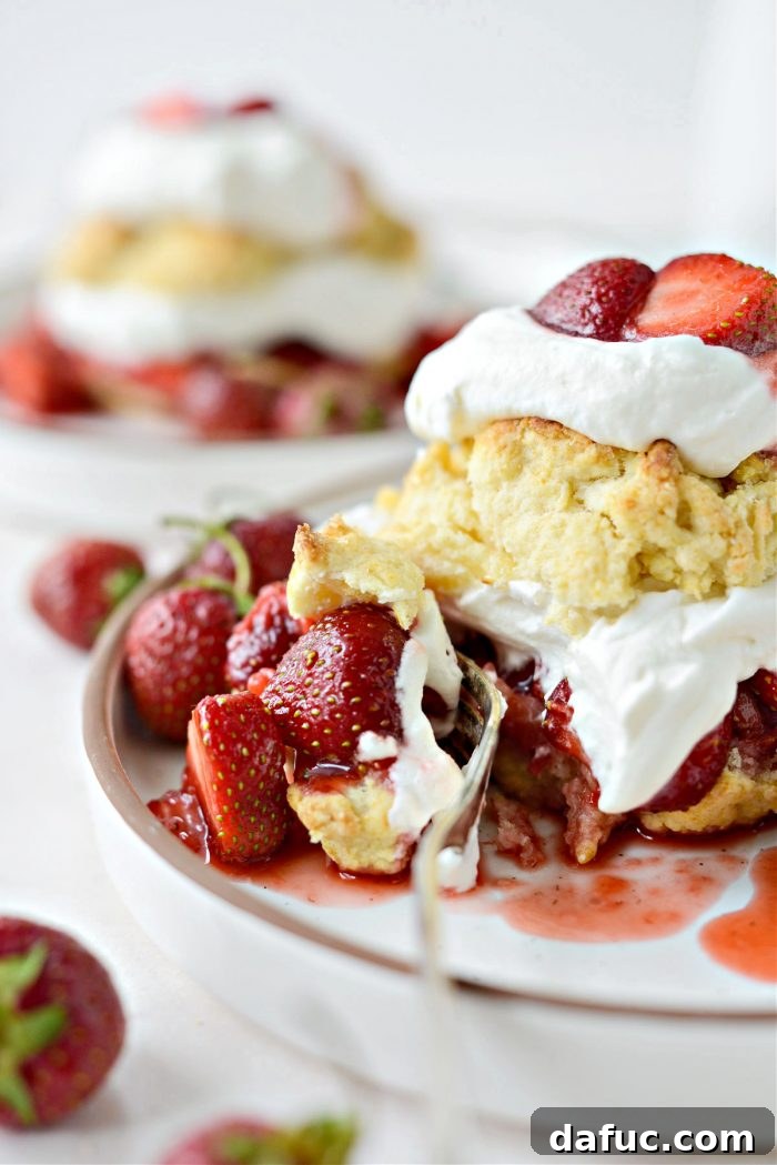 Another mouthwatering shot of Homemade Strawberry Shortcake with layers of biscuit, strawberries, and cream.