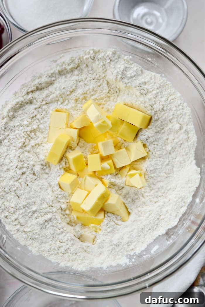 Adding cold cubed butter to dry ingredients for shortcake biscuits.