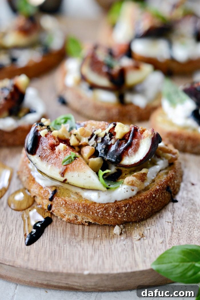 Another perspective of Honey Balsamic Fig and Burrata Crostini, highlighting the layers of ingredients and fresh garnishes.