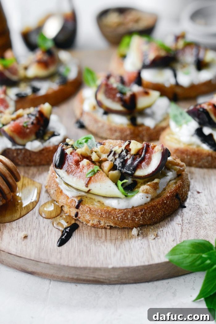 Close-up of freshly made Honey Balsamic Fig and Burrata Crostini on a serving platter, showcasing rich textures and vibrant colors.
