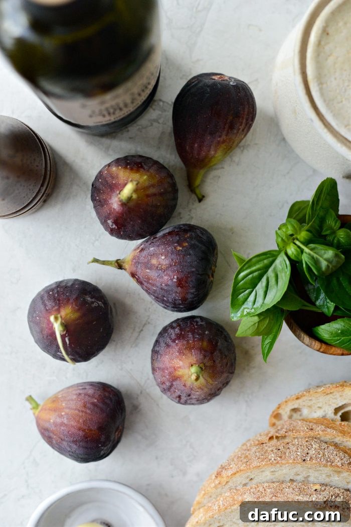 A close-up shot of several ripe, dark figs, halved and beautifully arranged, highlighting their vibrant interior and delicate seeds.