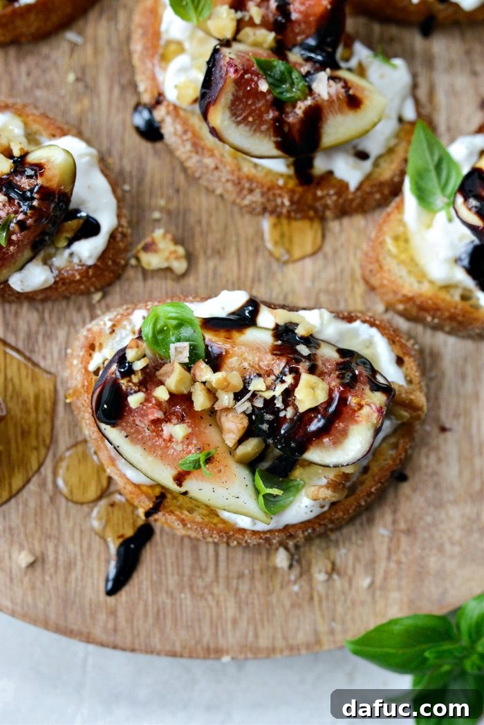 A completed Honey Balsamic Fig and Burrata Crostini, garnished with fresh basil leaves and ready to be served.