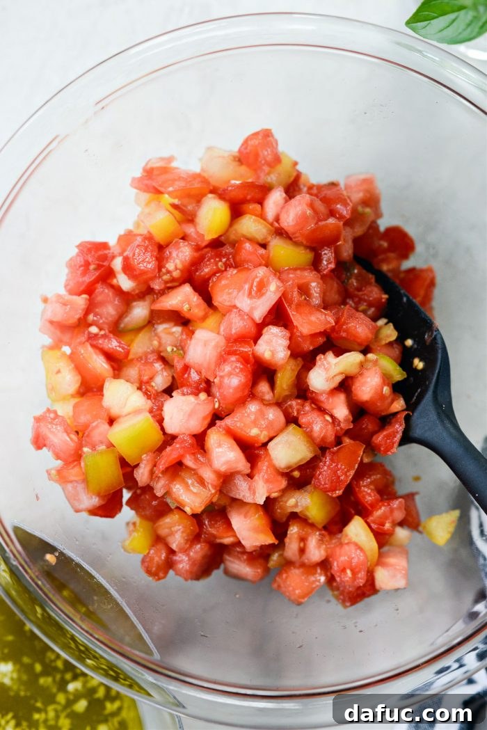 Vibrant Heirloom Tomato Bruschetta 14 Drained heirloom tomatoes being transferred from a colander into a clean mixing bowl.