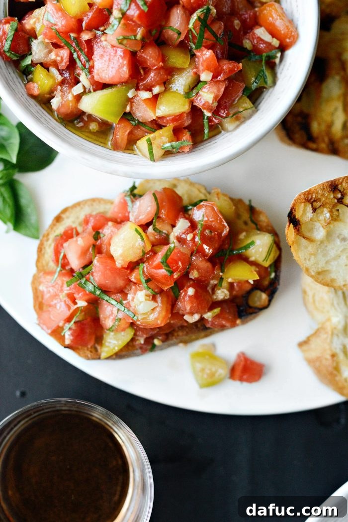 Vibrant Heirloom Tomato Bruschetta 19 An overhead shot of multiple servings of Heirloom Tomato Bruschetta arranged on a wooden board, ready for guests.