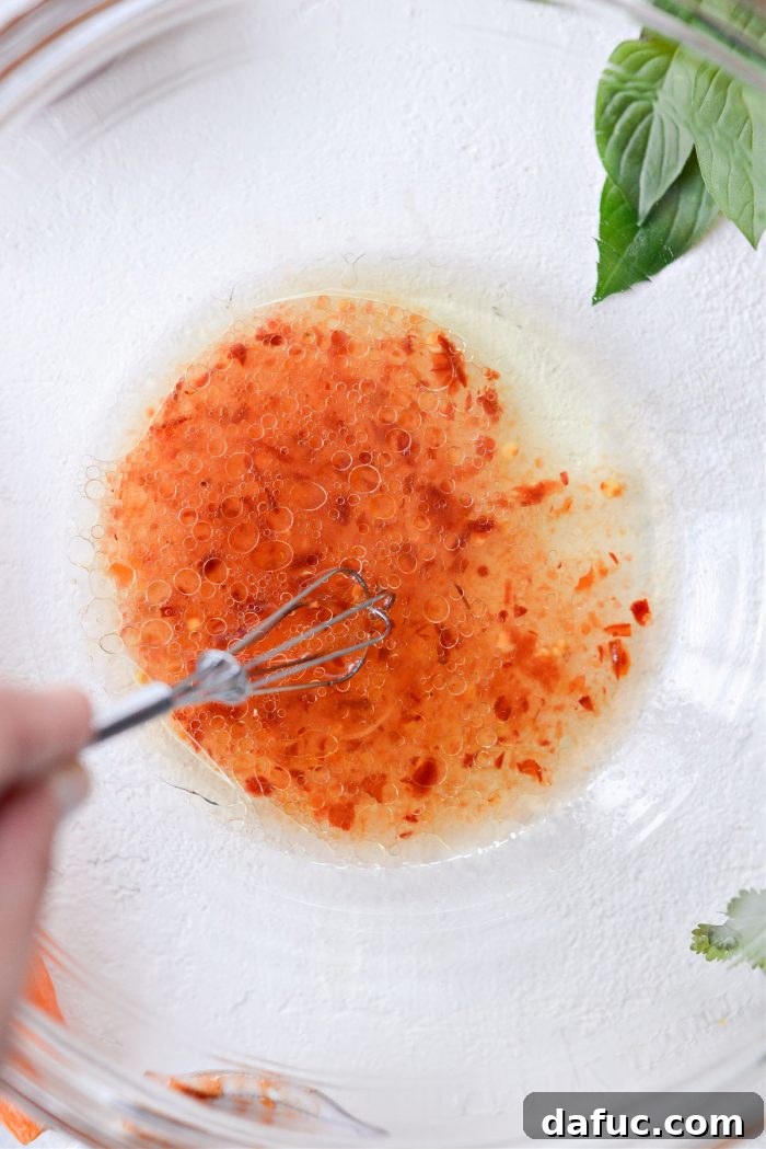 Vibrant Thai Carrot Slaw 5 A bowl of whisked dressing ingredients, showing a smooth, cohesive mixture.