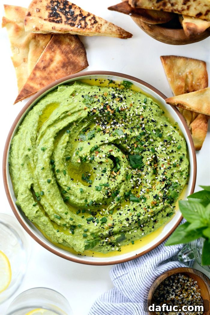 Vibrant Green Goddess Hummus 11 Green Goddess Hummus served in a bowl, drizzled with olive oil and topped with everything seasoning and fresh herbs