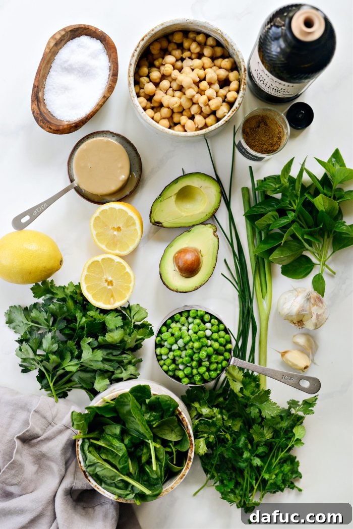 Vibrant Green Goddess Hummus 4 Fresh ingredients laid out for making Green Goddess Hummus: vibrant herbs, chickpeas, avocado, and spinach