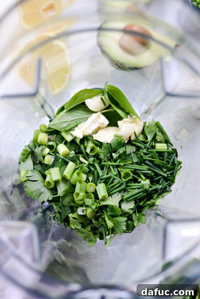 Vibrant Green Goddess Hummus 5 Fresh basil, cilantro, parsley, green onion, chives, and garlic in a blender ready for processing